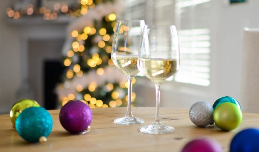 two champagne classes on the table with a christmas tree in the background