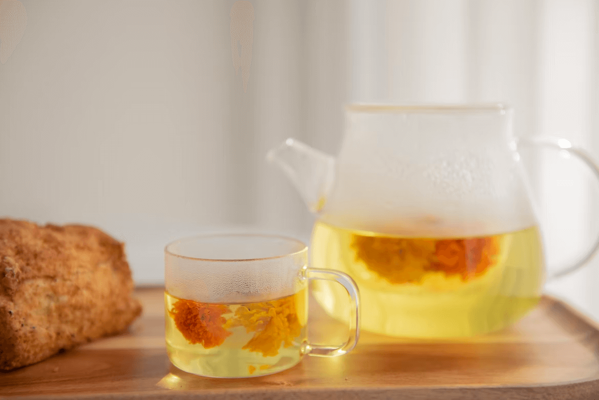 Teapot and tea cup full of yellow tea