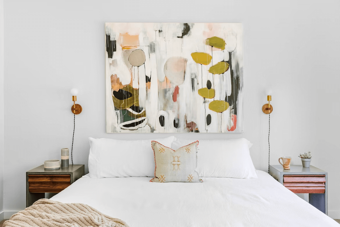 Bed with artistic print on the wall behind it
