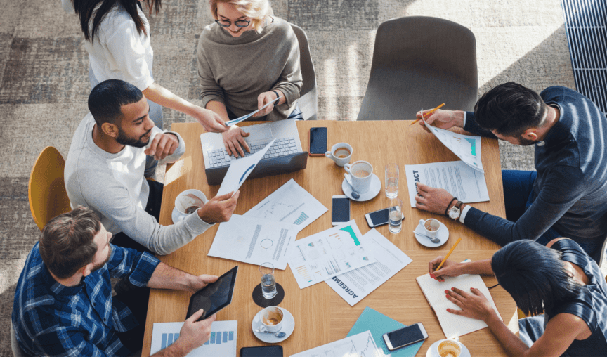 This is an image of people sitting around a table working.