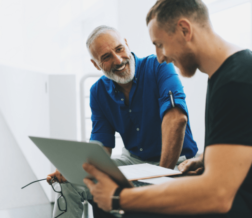 Two men discussing something over a laptoip