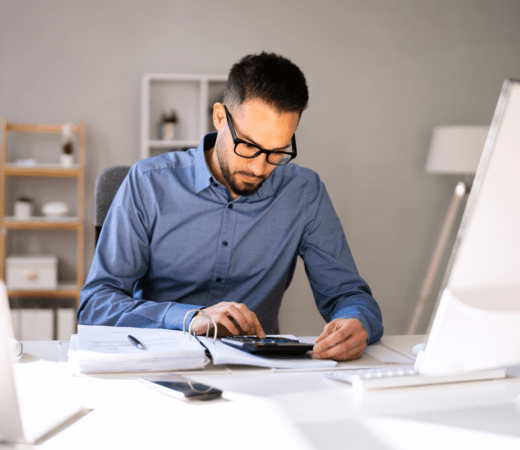 man working at his desk with the calculator